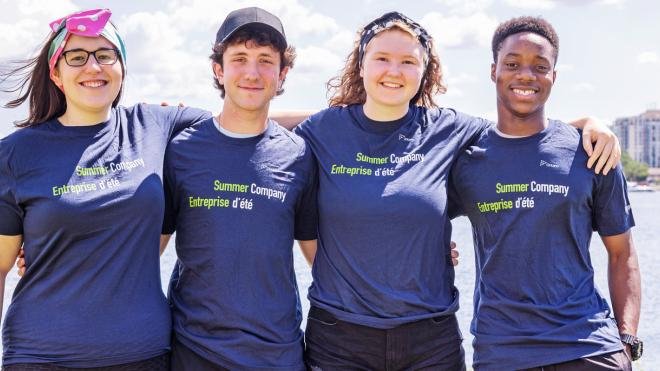 2 people wearing Summer Company t-shirts with waterfront in background