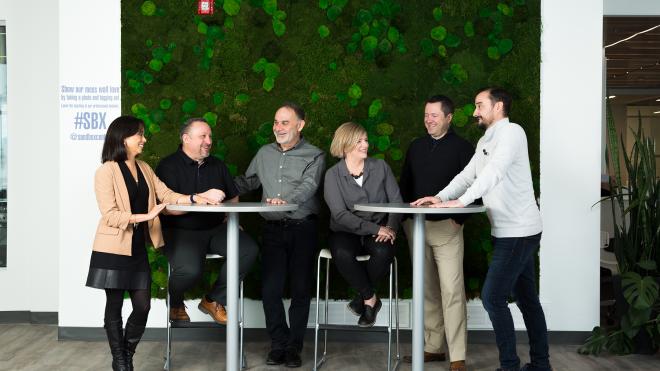 People gathered around tables talking with each other.